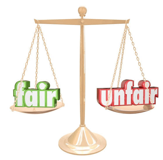 A balance scale with the words 'fair' in green on one side and 'unfair' in red on the other.